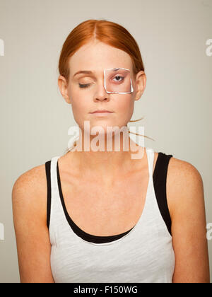 Studio shot of young woman wearing sleeveless top with artificial paper eye Stock Photo