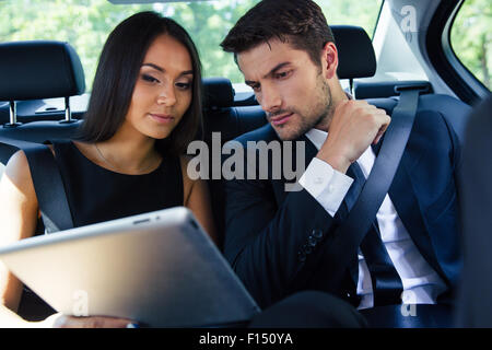 Beautiful couple using tablet computer in car Stock Photo