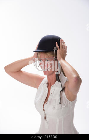 Portrait of a woman cricketer adjusting her safety helmet Stock Photo