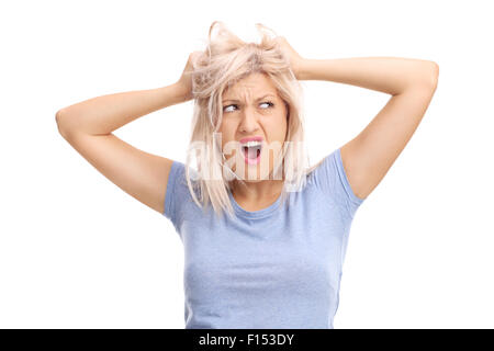 Frustrated young woman pulling her hair and screaming isolated on white background Stock Photo