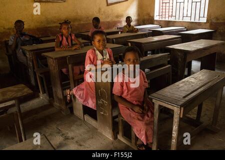 Young students sit in a mostly empty classroom as schools reopened after they were closed for three months during the Ebola outbreak January 19, 2015 in Conakry, Guinea.  More than 80,000 teachers from pre-primary to university levels have been trained to help fight the epidemic. Stock Photo
