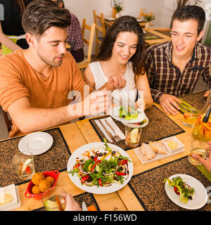 Friends at the restaurant and being served of food in the plate Stock Photo