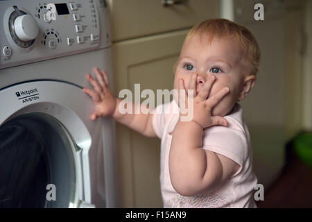 A teething eleven month old baby chewing on her fingers to alleviate the discomfort of tooth ache. Stock Photo