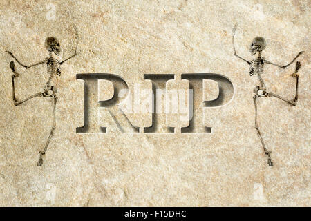 Engraved headstone spelling the letters RIP with Skeletons - rest in peace Stock Photo