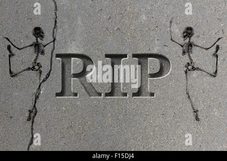 Engraved headstone spelling the letters RIP with Skeletons - rest in peace Stock Photo