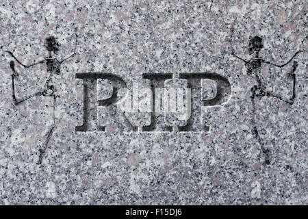 Engraved headstone spelling the letters RIP with Skeletons - rest in peace Stock Photo