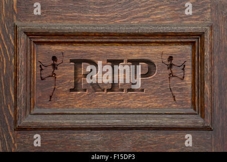 Engraved coffin spelling the letters RIP with Skeletons - rest in peace Stock Photo