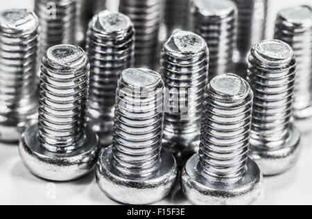 Closeup metal screw (bolt) and nuts on white background. Stock Photo