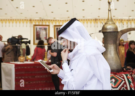 Arab man reading text on mobile phone, cell phone. Arabian people. Stock Photo