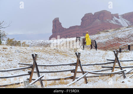 Cowboy Riding Horse in Snow, Rocky Mountains, Wyoming, USA Stock Photo