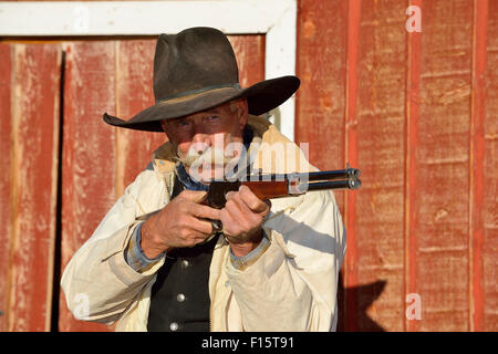 Portrait of Cowboy Aiming Rifle, Shell, Wyoming, USA Stock Photo