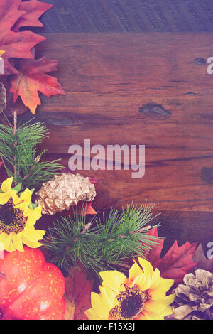 Autumn Fall rustic background on vintage distressed dark wood with autumn leaves and decorations with added retro vintage style Stock Photo