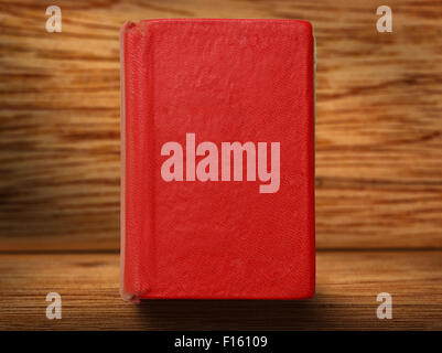 Old red book on wooden background closeup Stock Photo