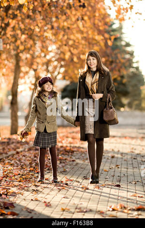 Vertical photo,  happy beautiful little girl with mather  walking in park Stock Photo