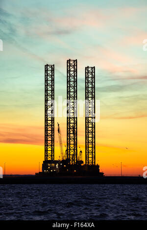 Oil drilling rig at sunset time. Stock Photo