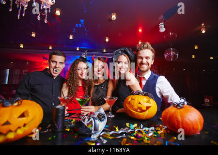 Young people posing in Halloween hats and with pumpkins Stock Photo