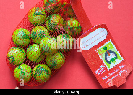 Christmas foil wrapped chocolate sprouts - milk chocolate balls with creme filling ready for Christmas set on red background Stock Photo