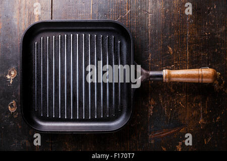 Black iron empty grill pan on Old dark brown wooden texture background Stock Photo