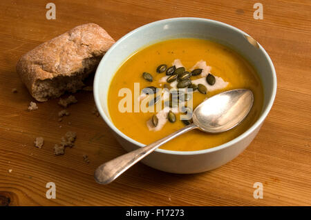 Squash soup with oregano, goats cheese and pumpkin seeds. Stock Photo