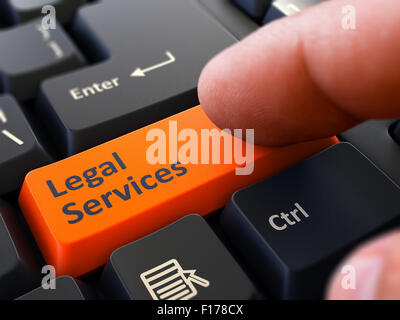 Computer User Presses Orange Button Legal Services on Black Keyboard. Closeup View. Blurred Background. Stock Photo