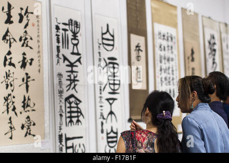 Los Angeles, USA. 29th Aug, 2015. Visitors look at works displayed during a calligraphy art exhibition for commemorating the 70th anniversary of the victory of the Chinese People's War of Resistance Against Japanese Aggressions and the World Anti-Fascist War, in Los Angeles, California, the United States, Aug. 29, 2015. © Zhao Hanrong/Xinhua/Alamy Live News Stock Photo