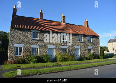 Semi-detached cottages in the picturesque village of Hovingham, in the Ryedale district of North Yorkshire. Stock Photo