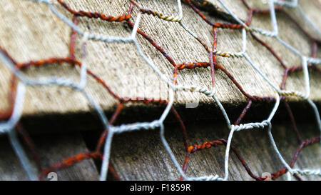 Detail of rusty chicken wire on wooden tiles Stock Photo