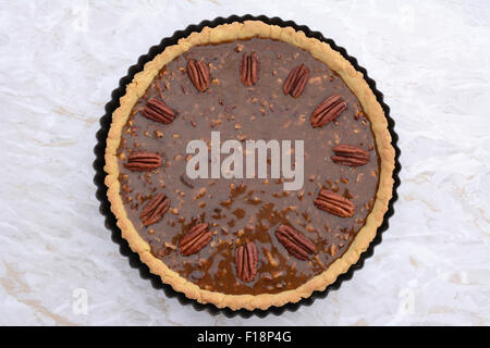 Pecan pie decorated with toasted nuts ready to be baked in the oven Stock Photo
