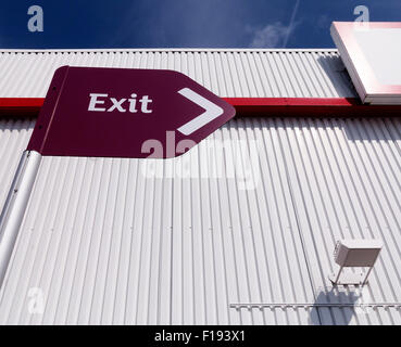 Exit sign in front of a white wall on a sunny day Stock Photo