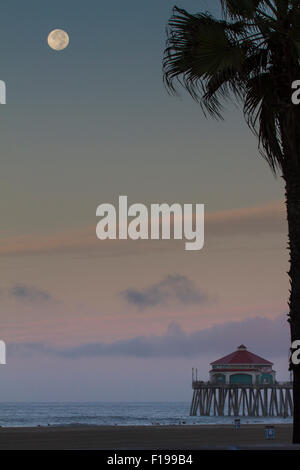Huntington Beach, California, USA. 30th August, 2015. The supermoon is seen sinking into the west over Huntington Beach Pier in Stock Photo