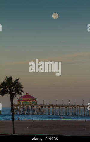 Huntington Beach, California, USA. 30th August, 2015. The supermoon is seen sinking into the west over Huntington Beach Pier in Stock Photo