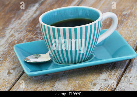 Black coffee in vintage stripy cup and cinnamon sticks on rustic wooden ...