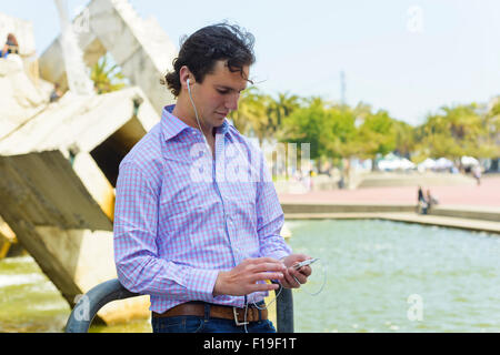 young man enjoys information, music, and information on the go. Stock Photo