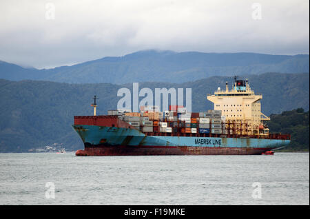 WELLINGTON, NEW ZEALAND, JULY 27, 2015: Tug boats guide a container ship into port at Wellington, New Zealand Stock Photo