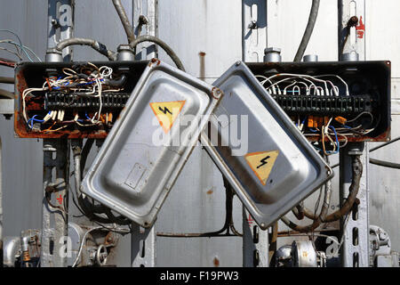 Old rusty electric transformer box with wires Stock Photo