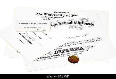 Education certification documents including high school diploma,commencement ticket, and university degree isolated on white Stock Photo