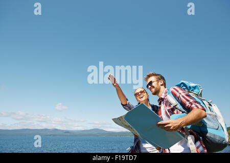 Cheerful hikers with map choosing route for travel Stock Photo
