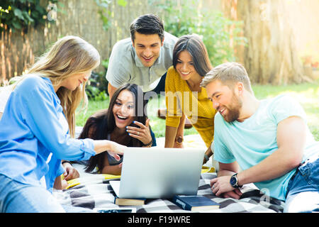 Happy student using laptop in campus Stock Photo