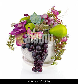 Colorful composition made of artificial flowers and fruits in an old glass vase isolated on white background. Stock Photo