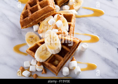 Waffles with peanut butter and bananas topped with caramel syrup Stock Photo