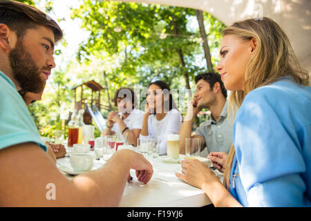 Group of a happy friends sitting at the table in outdoor restaurant Stock Photo