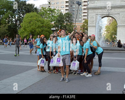 NYU students & greeters to incoming freshmen pose for a selfie in Washington Square Park in New York City Stock Photo