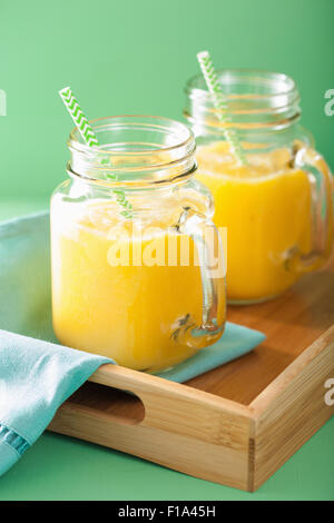 healthy yellow smoothie with mango pineapple banana in mason jars Stock Photo