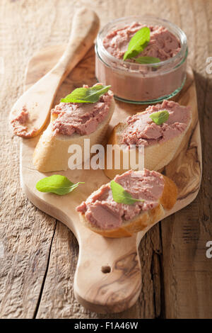 healthy chicken liver pate with sage in jar and on bread Stock Photo