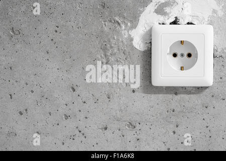 Energy, Electric Plug on a concrete wall Stock Photo