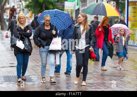 Northampton, U.K. 31st Aug 2015. People under colourful umbrellas in the town centre on a this wet August Bank holiday Monday in Abington street, Northampton, nearly midday and there's still heavy rain falling latest forecast is that it will subside by mid afternoon. Credit:  Keith J Smith./Alamy Live News Stock Photo