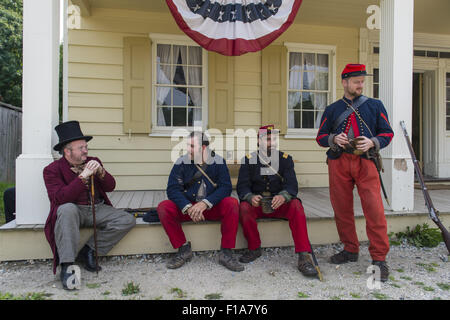 Old Bethpage, New York, USA. 30th Aug, 2015. L-R in soldier uniforms, Sean Sullivan from Greenlawn, Andrew Preble from Long Beach, and Matt Dellinger from Brooklyn, portray American Civil War soldiers from the 14th Brooklyn Regiment (14th New York State Militia) AKA The Brooklyn Chasseurs, at the Noon Inn tavern during the Old Time Music Weekend at the Old Bethpage Village Restoration. During their historical reenactments, members of the non-profit 14th Brooklyn Company E wear accurate reproductions of ''The ''Red Legged Devils'' original Union army uniform. (Credit Image: © Ann Par Stock Photo