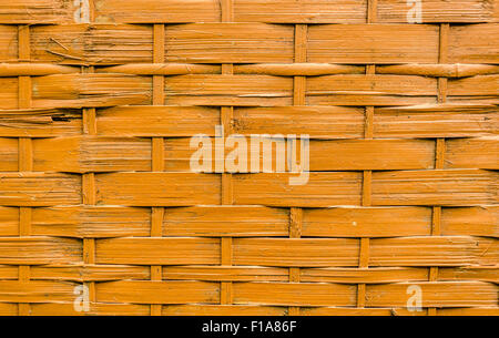 Close-up of orange painted natural bamboo wood strips woven background. Stock Photo