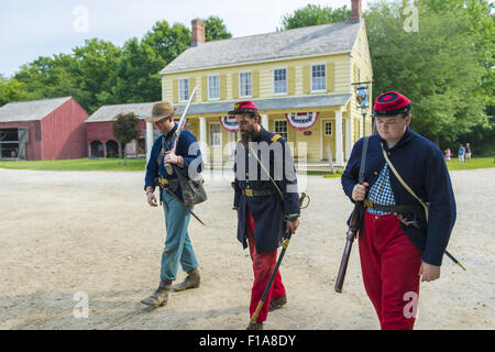 Old Bethpage, New York, USA. 30th Aug, 2015. At center, Andrew Preble from Long Beach portrays an American Civil War Captain from the 14th Brooklyn Regiment (14th New York State Militia) AKA The Brooklyn Chasseurs, in front of the yellow and white Noon Inn tavern during the Old Time Music Weekend at the Old Bethpage Village Restoration. During their historical reenactments, members of the non-profit 14th Brooklyn Company E wear accurate reproductions of ''The ''Red Legged Devils'' original Union army uniform. Credit:  Ann Parry/ZUMA Wire/Alamy Live News Stock Photo