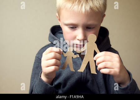 Confused child with cutting paper father and son, family problems, divorce, custody battle, suffer concept Stock Photo